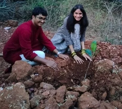Ruthuparna and Anarghya planting a sapling together in red earth