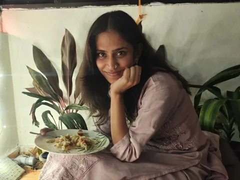 Anarghya smiling on a beanbag with her plate