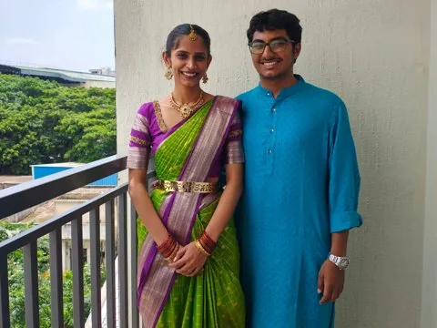 Her in a green silk saree and him in a blue kurta at Aishu's housewarming