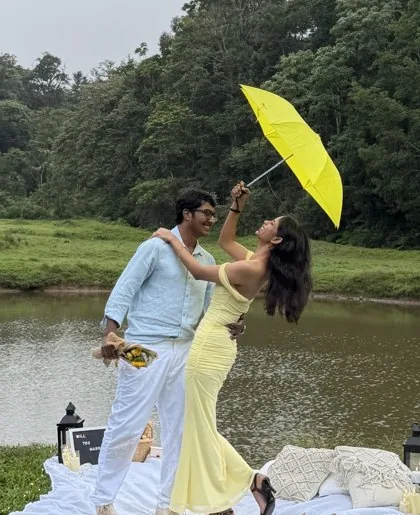 Anarghya twirling the yellow umbrella as he holds her